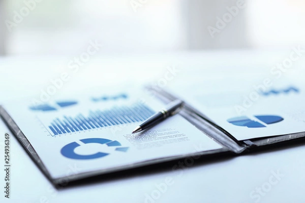 Obraz background image of a clipboard with financial report on table