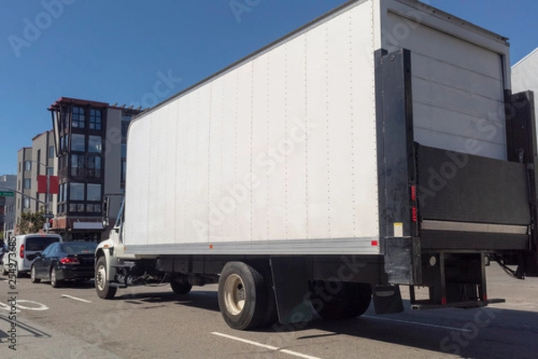 Fototapeta Rear and side view of shipping transportation in traffic.