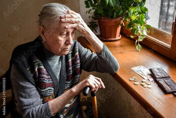 Fototapeta Portrait of an old woman counting money, euros. The concept of old age, poverty, austerity.