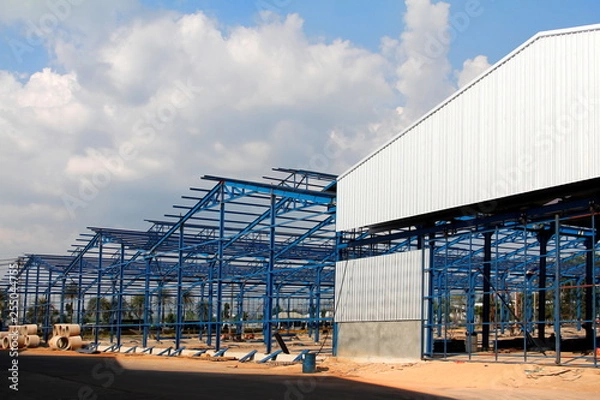 Fototapeta Structure of steel roof frame for building construction on sky background
