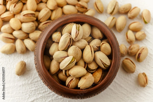 Obraz Bowl of pistachio close up, and pistachio on a kitchen table, view from the above