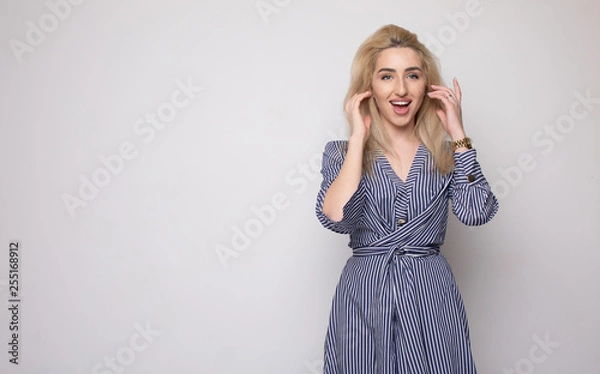 Fototapeta Happy smiling young businesswoman, on grey background. Caucasian blonde model in business concept studio shoot. Blank copyspace area for advertise text or slogan