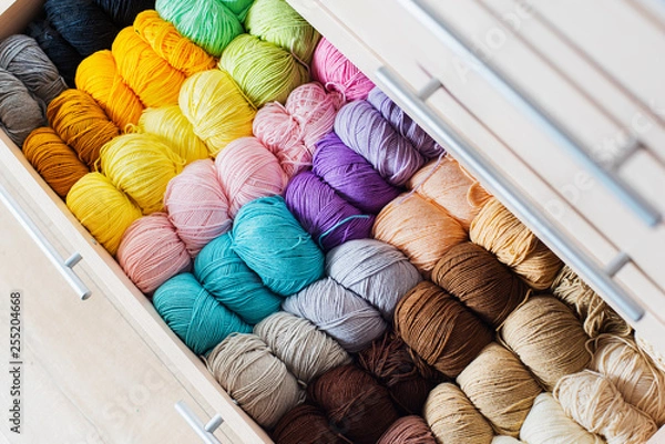 Fototapeta Needlework and crocheting and knitting. . Colorful multicolored skeins of yarn in the dresser. Women's hobby.