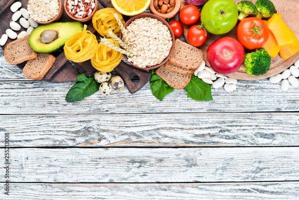 Fototapeta Concept of healthy food: bread, pasta, avocado, flour, pumpkin, broccoli, beans, spinach. Vegetables and fruits. Top view. Free copy space.