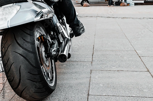 Obraz Motorcycle wheel close up on the road. Biker sitting on a motorcycle close-up.
