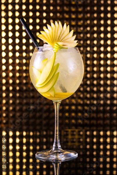 Obraz Yellow fruit cocktail with lemon in tall round glass