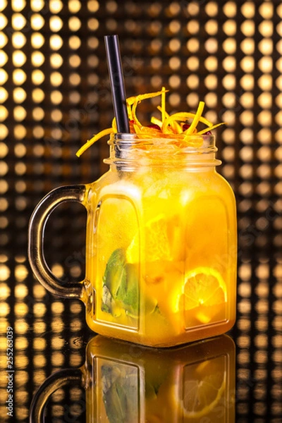 Obraz Yellow fruit cocktail lemonade with fresh lemon in vintage jar
