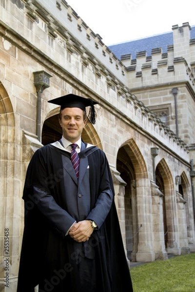 Obraz A portrait of a young European man in a graduation gown.
