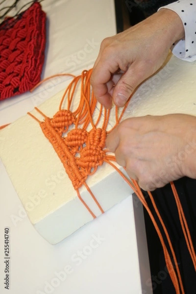 Fototapeta Women's hands weave macrame