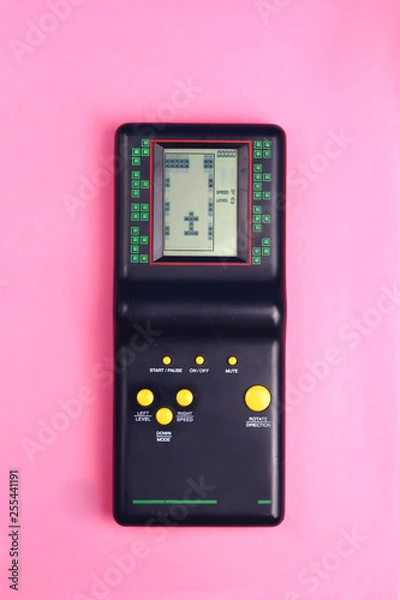 Fototapeta Black tetris game console on pink background retro and group 80s and 90s style with yellow buttons game from childhood