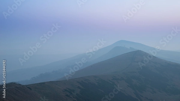 Fototapeta Stunning Winter sunrise landscape image of The Great Ridge in the Peak District in England with mist hanging around the peaks