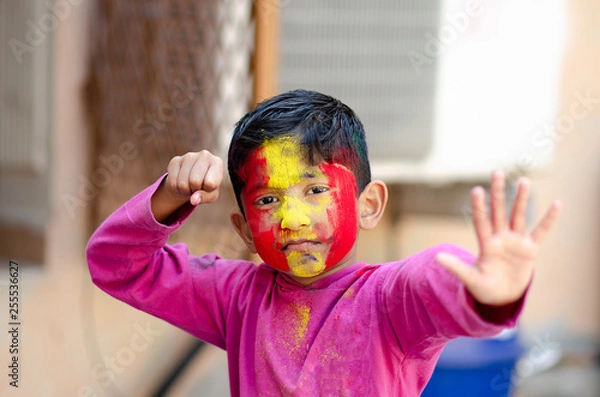Obraz Cute Little Indian boy child with coloured face during holi indian festival looking at camera