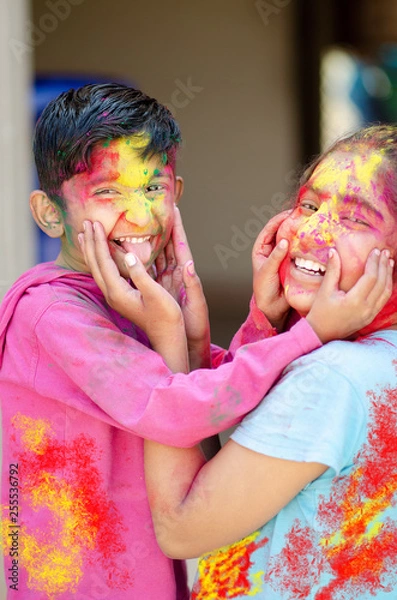 Obraz Śliczne urocze rodzeństwo bawiące się kolorami podczas festiwalu holi kolorów Indyjski azjatycki kaukaski kreatywny portret