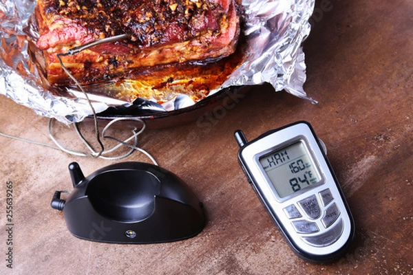 Obraz Grilled Steak in a pan and Wireless Remote Digital Cooking Food Probe Meat Thermometer For Grill on a black background. Copy space.