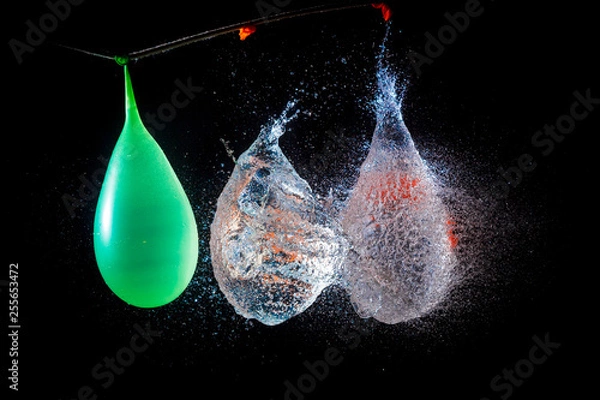 Fototapeta Amazing explosion big water color balloon bomb with splash  water on isolated  black background with flash. Сoncept of freezing moment of time.