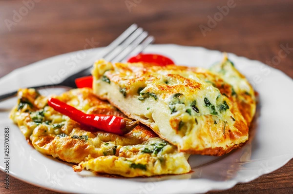 Fototapeta omelet with spinach in white plate on wooden table background