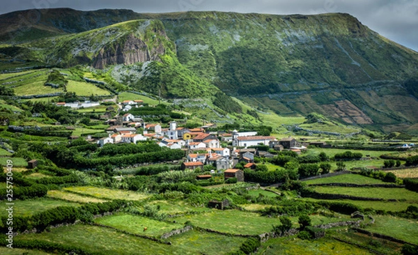 Fototapeta Azores landscape: The village of Mosteiro on the island of Flores, the Azores, Portugal, with on the background Rocha dos Bordoes, a volcanic Basalt rock.