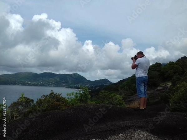 Obraz The man on the cliff taking pictures of the seascape