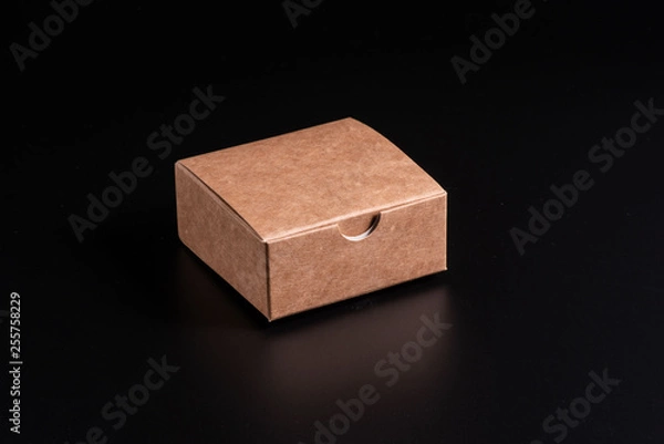 Obraz Kraft cardboard box on a black background, moke up