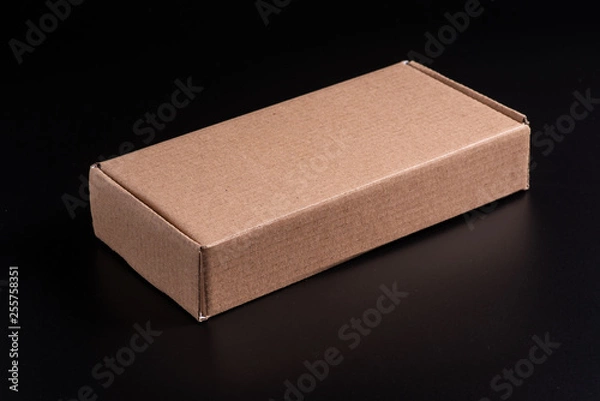 Obraz Kraft cardboard box on a black background, moke up