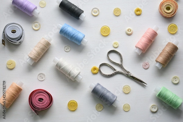 Fototapeta Composition with threads and sewing accessories on a white background, flat lay