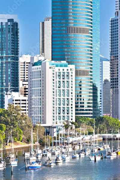 Fototapeta Close view of a city buildings with running ships
