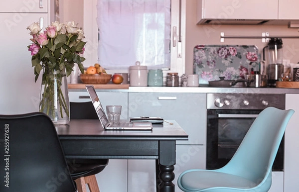 Obraz Computer on the table in the kitchen. Work at home and freelance. Cozy home. Free space for text.