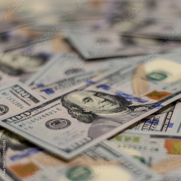 Obraz Macro shot of Benjamin Franklin's portrait on a new 100 dollar US money note, with defocused background of many more identical money notes in a mess.
