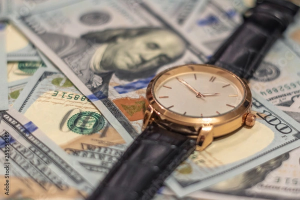 Obraz Wrist gold watch lie on the bills of 100 dollar money. Soft focus.