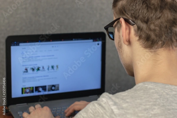 Obraz man with glasses working at a laptop at home. soft focus. home work concept