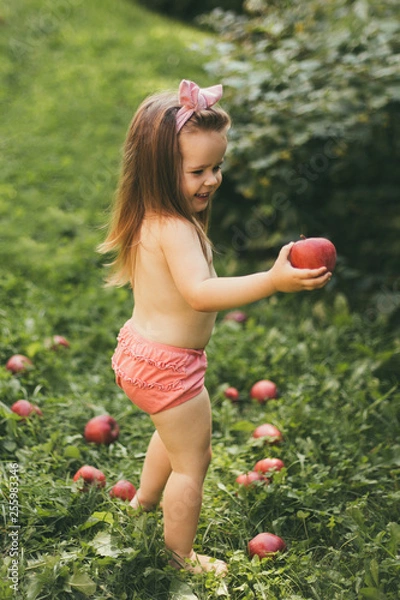 Obraz Girl with apples on the green grass