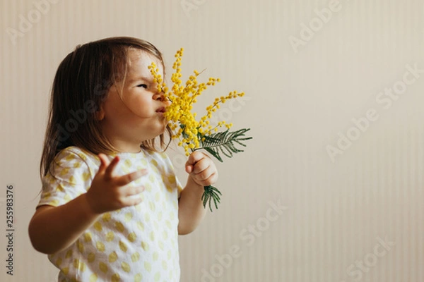 Obraz Child smelling a mimosa