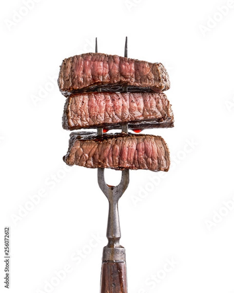 Obraz Slices of beef steak on vintage fork isolated on white
