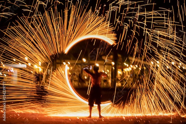 Fototapeta Fire dancers Swing fire dancing show fire show on the beach dance man juggling with fire