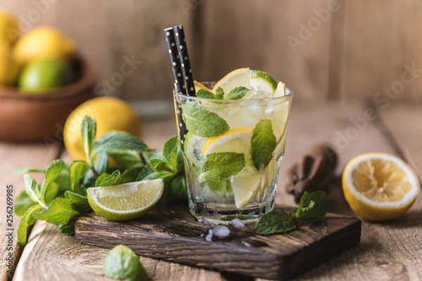 Obraz Mojito cocktail with lime, lemon and mint in a glass on a dark rustic background. Fresh summer cocktail. Lemon mojito