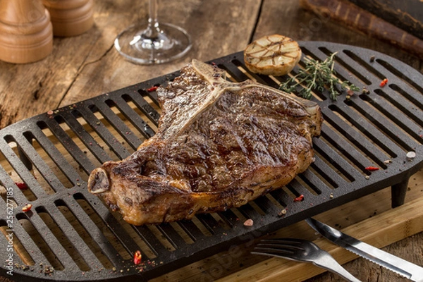Obraz Grilled Striploin steak on grill on wooden table