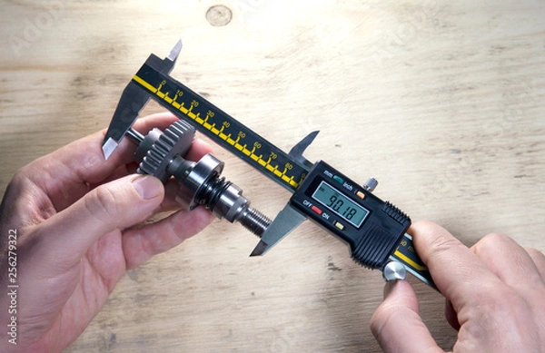 Obraz male hands with digital caliper