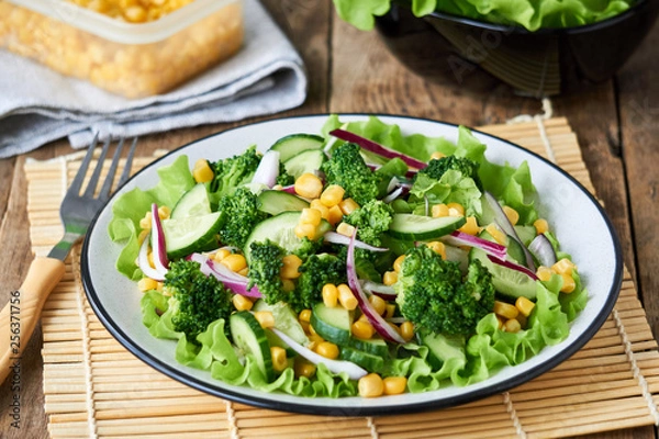 Fototapeta Vegetable salad with broccoli, corn and cucumbers on a plate