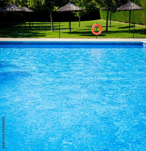 Obraz Closeup view of the swimming pool edge with blue water copy space during a sunny summer day