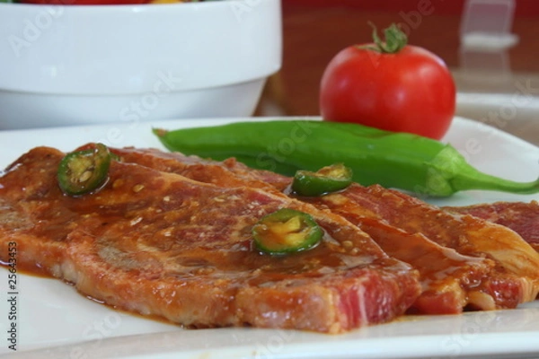 Fototapeta Short Ribs on a plate with a pepper and tomato garnish