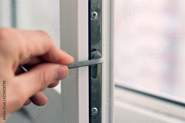 Obraz Workman adjusts the operation of the plastic window.