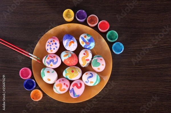 Fototapeta painted Easter eggs, paintbrush and paint on the table. preparation for Easter. wooden table.