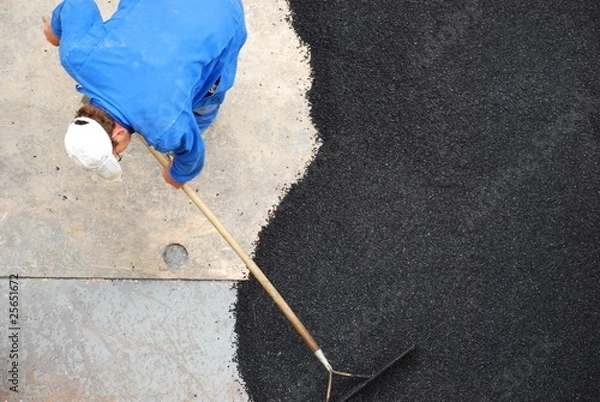 Obraz Bauarbeiter verteilt Bitumen auf der Straße