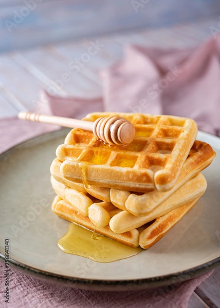 Fototapeta Waffles with honey on a light background.