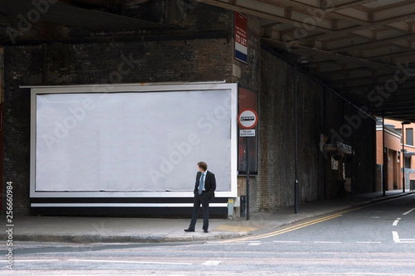 Obraz A businessman looking at a blank billboard