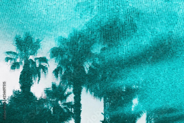 Fototapeta Small elements turquoise mosaic on the bottom of the pool pattern. Reflections of palm trees on the water surface. Travel background. Close up.