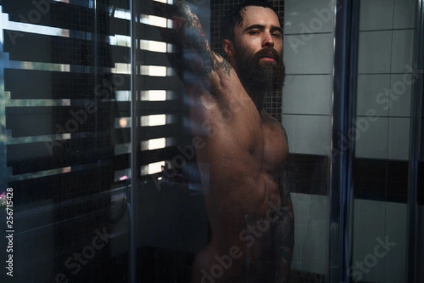 Obraz A bearded guy with a tattoo in the shower.Sexy guy in the shower.