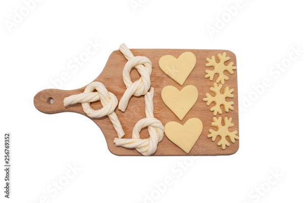 Fototapeta cheese slices on cutting board. bow, snowflake heart shaped cut cheese