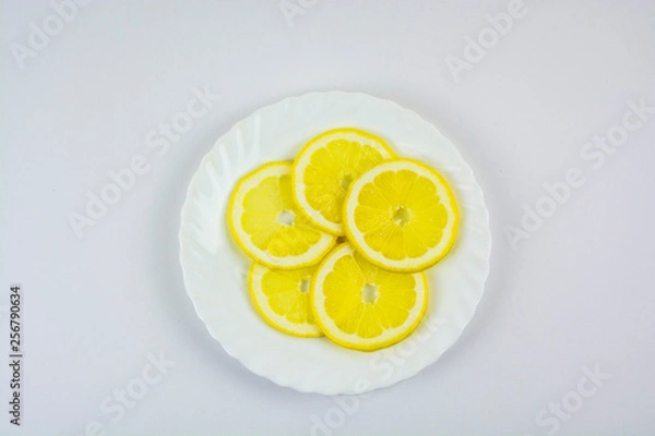 Obraz sliced lemons on a white plate