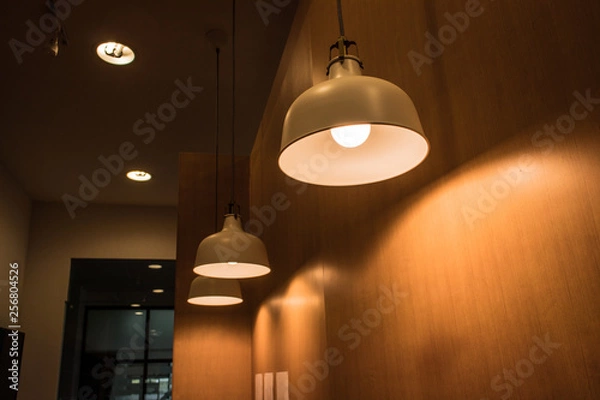 Fototapeta Lighting fixture lamps are hanging on textile classic cable from the ceiling